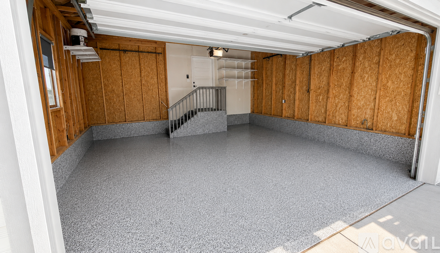 A spacious room with wooden walls and a grey floor.