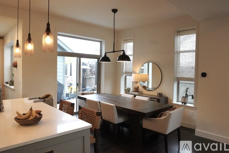 A kitchen with a table and chairs and pendant lights.