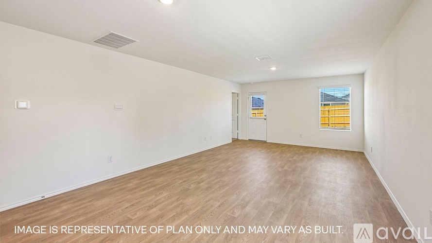 A spacious room with wooden flooring and white walls.