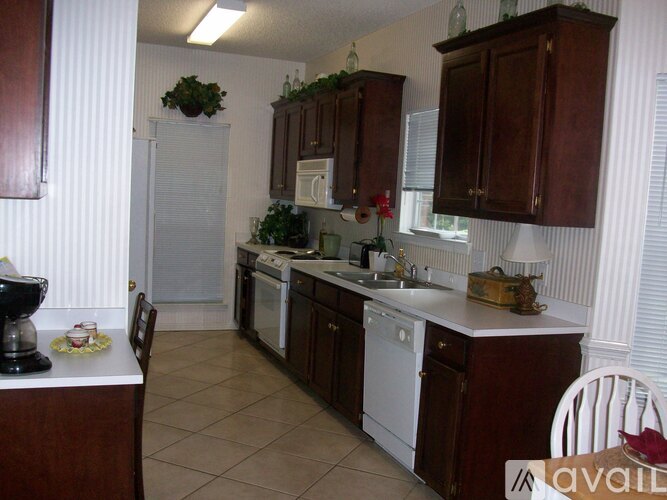A kitchen with brown cabinets and white appliances.
