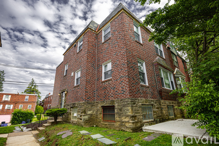 A red brick building with a stone foundation and a green lawn in front.