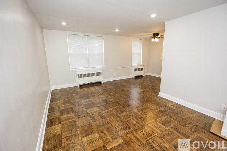 A room with wooden flooring and white walls.