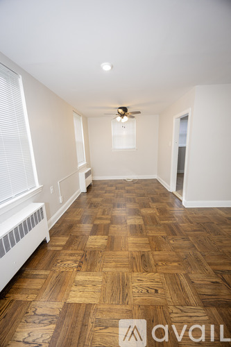 A room with wooden flooring and a ceiling fan.