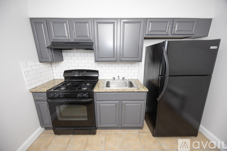 A kitchen with a black fridge, stove and oven.