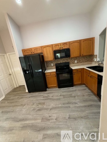 A kitchen with black appliances and wooden cabinets.