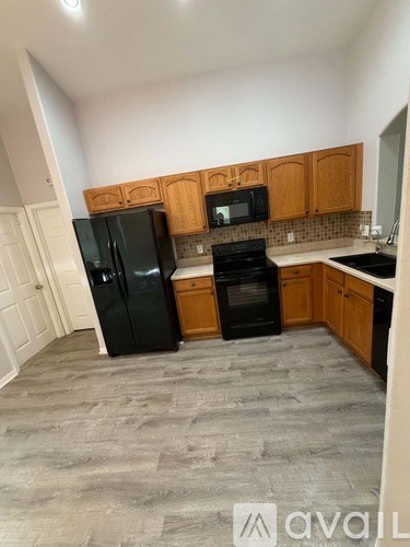 A kitchen with black appliances and wooden cabinets.