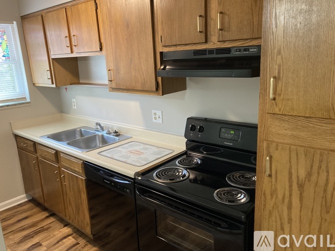 A kitchen with wooden cabinets and a black stove top oven.