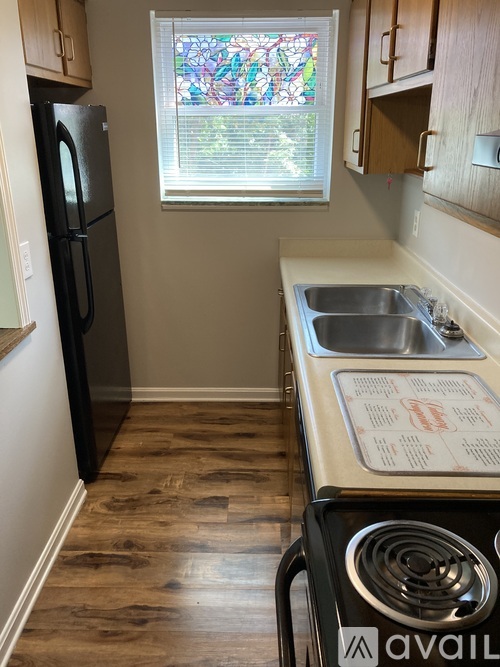 A kitchen with a black fridge and a stove top oven.