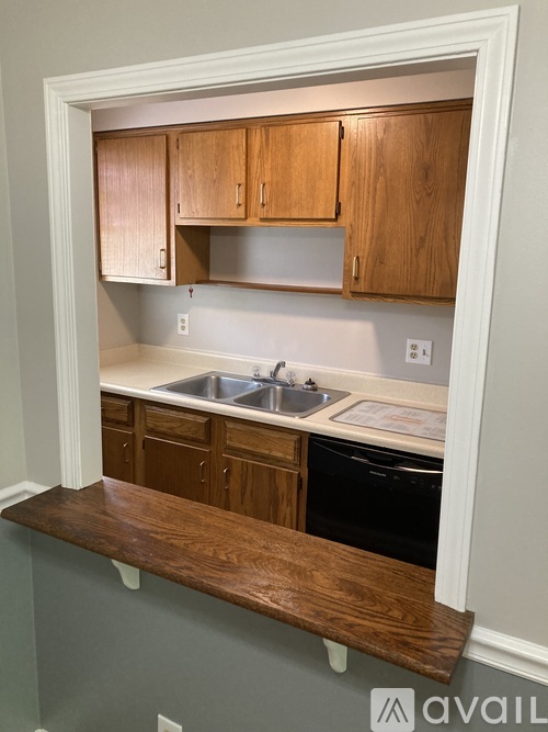 A kitchen with wooden cabinets and a white countertop.
