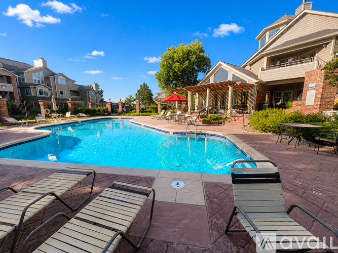 A pool surrounded by lounge chairs and umbrellas.