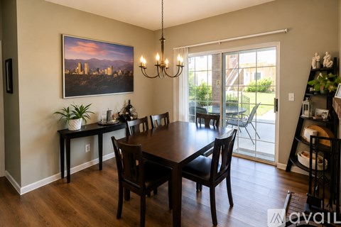 A dining room with a wooden table and chairs.
