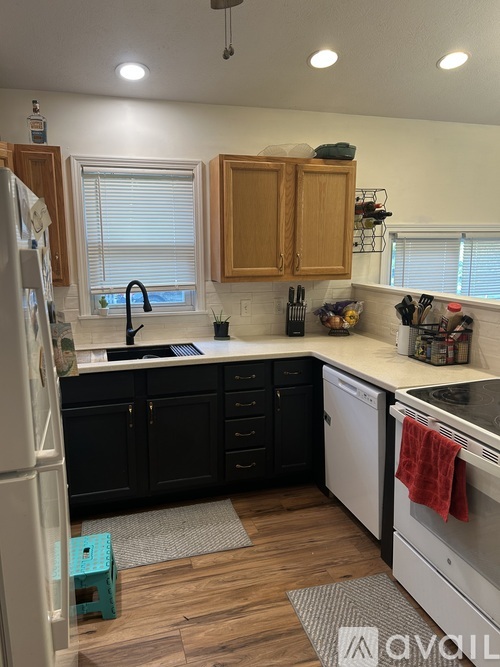 A kitchen with black cabinets and a white refrigerator.