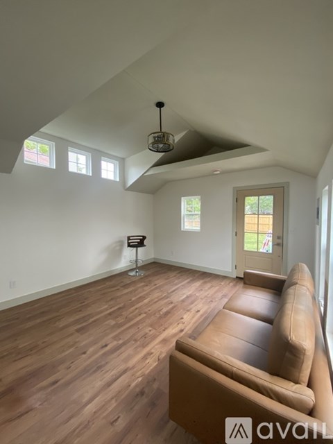 A living room with a brown couch and a wooden floor.