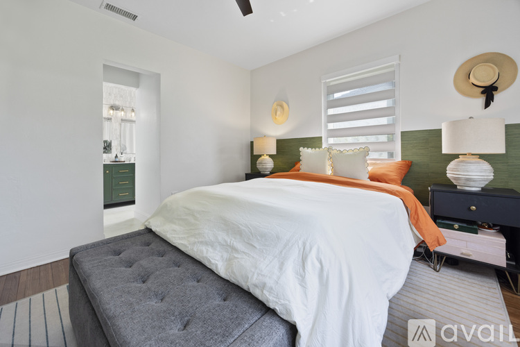 A bedroom with a large bed and a ceiling fan.