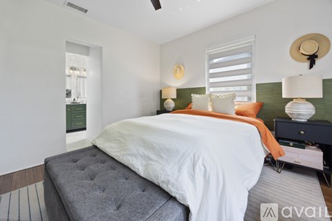 A bedroom with a large bed and a ceiling fan.