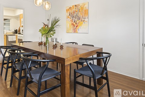 A dining room with a wooden table and chairs.