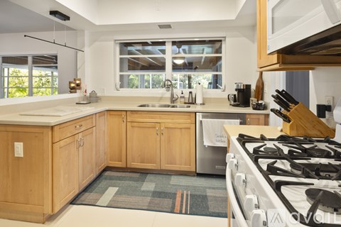A kitchen with wooden cabinets and a white stove top.