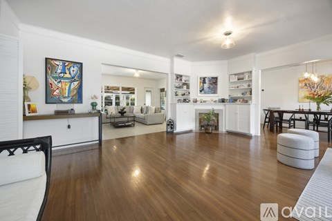 A living room with a white couch and a painting on the wall.