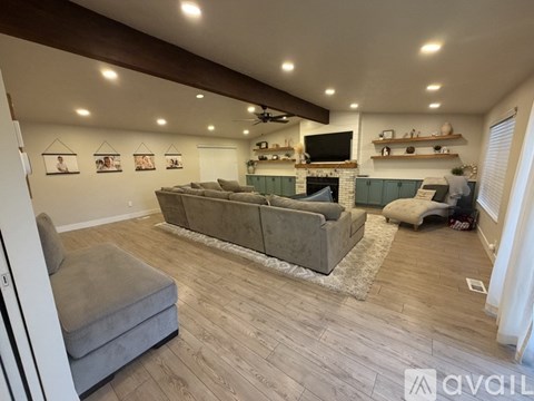 A living room with a grey couch and a fireplace.