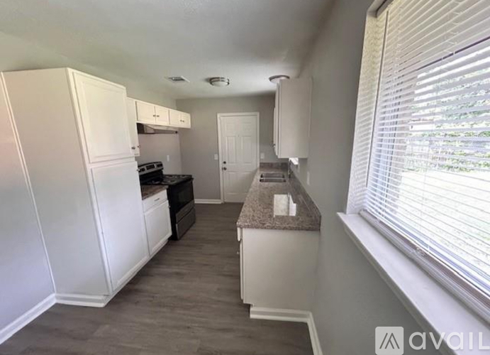 A kitchen with white cabinets and a countertop.