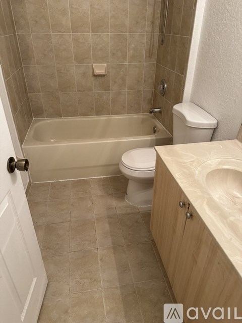 A bathroom with a tub, toilet and sink.