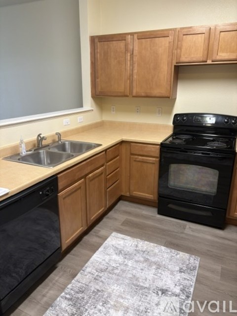 A kitchen with wooden cabinets and a black oven.