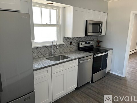 A kitchen with white cabinets and a black stove top oven.