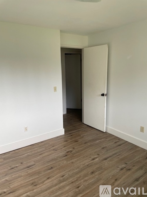 A room with a wooden floor and a white door.