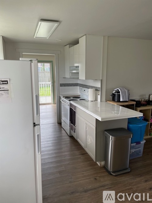 A kitchen with a white fridge and a white counter top.