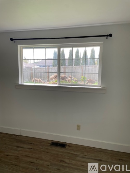 A room with a window and wooden flooring.