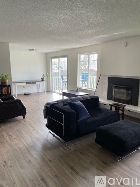 A living room with a black sofa and a fireplace.