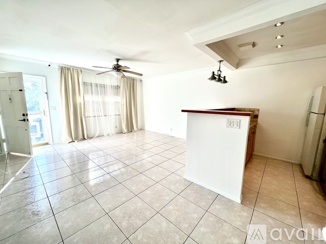 A spacious room with a fan and a white cabinet.