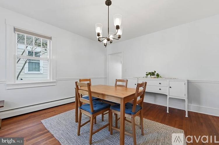 A dining room with a wooden table and chairs.