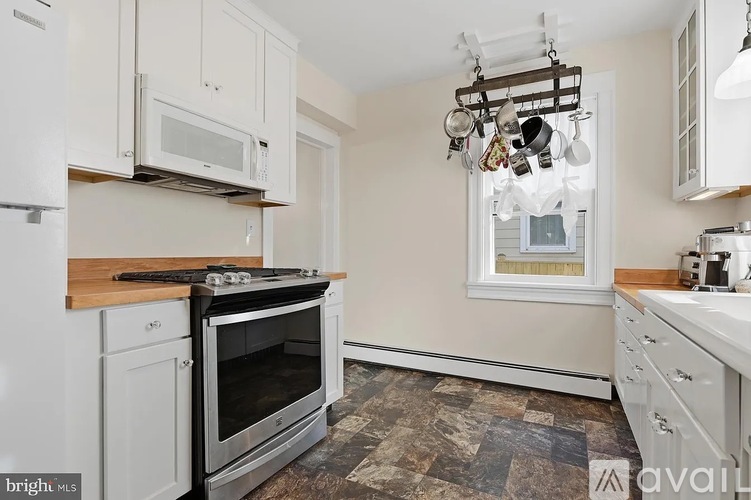 A kitchen with white cabinets and a black stove top oven.