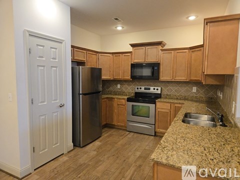 A kitchen with wooden cabinets and granite countertops.