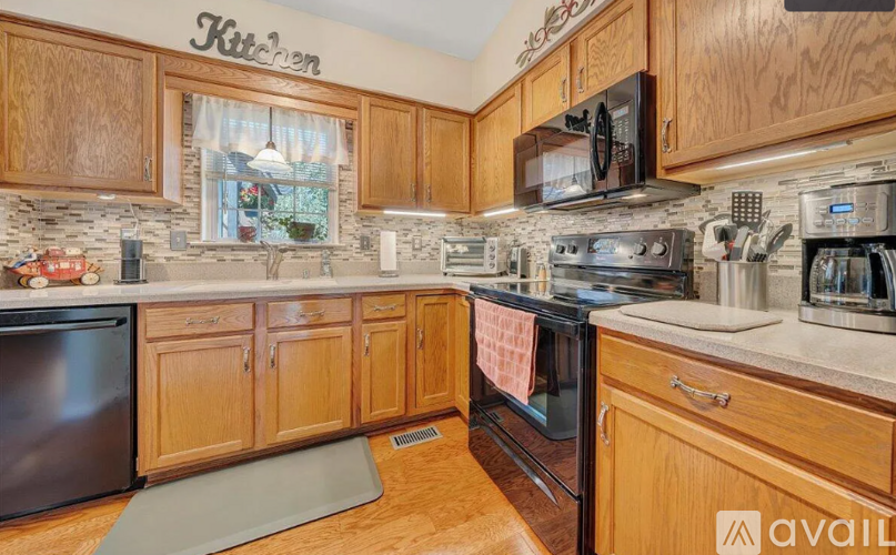 A kitchen with wooden cabinets and a stone backsplash.