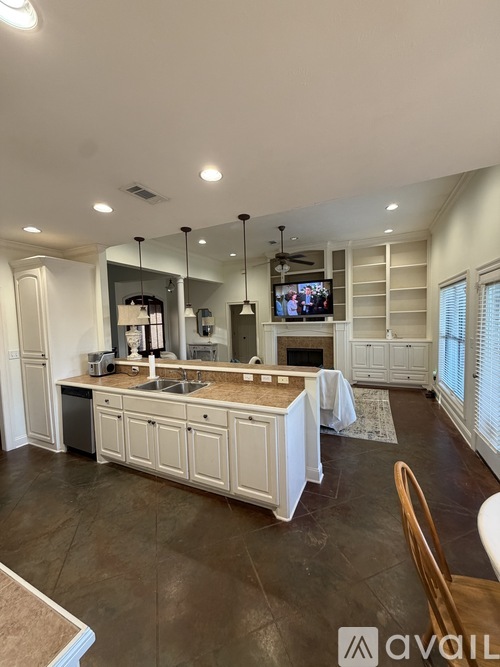 A modern kitchen with white cabinets and a dark floor.