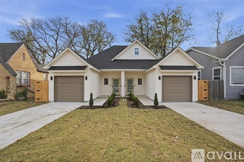 A two-story house with a front yard and two garages.