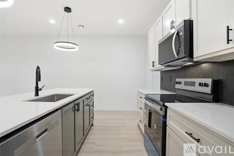 A modern kitchen with a black microwave above the stove.