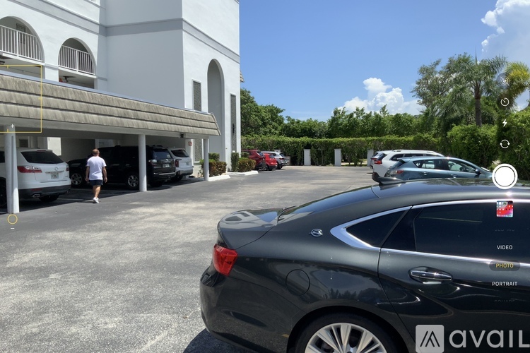 A black car is parked in a parking lot with a sign that says "available" on the back.
