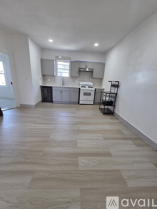 A kitchen with white appliances and a tiled floor.