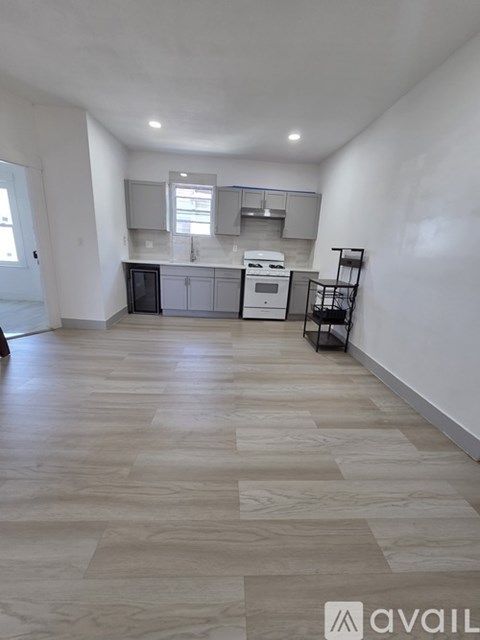 A kitchen with white appliances and a tiled floor.