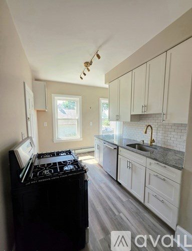 A kitchen with a black stove top oven and white cabinets.