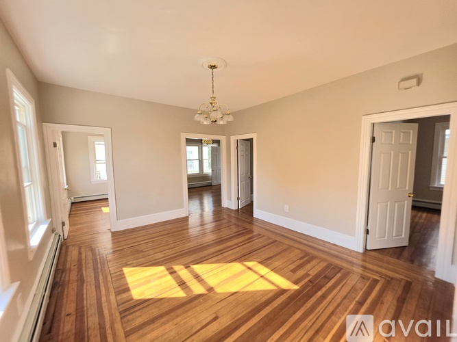 A room with wooden floors and a chandelier.