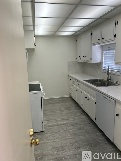 A kitchen with white cabinets and a sink.