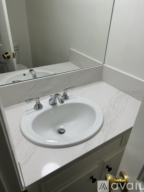 A white sink with a silver faucet is in a bathroom.
