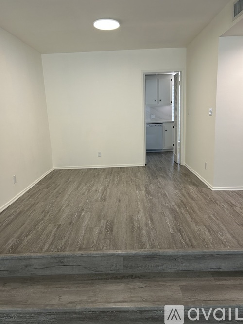 A room with a wooden floor and a white door.
