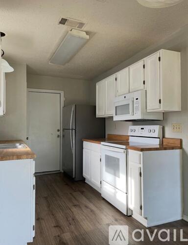 A kitchen with white appliances and cabinets.