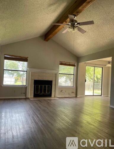 A room with a fireplace and a ceiling fan.