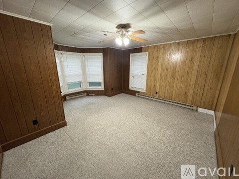 A room with wooden walls and a carpeted floor.